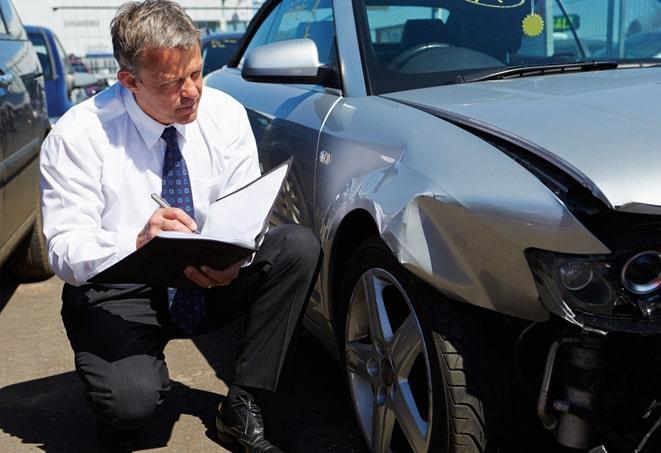 hand holding auto insurance policy paperwork with pen